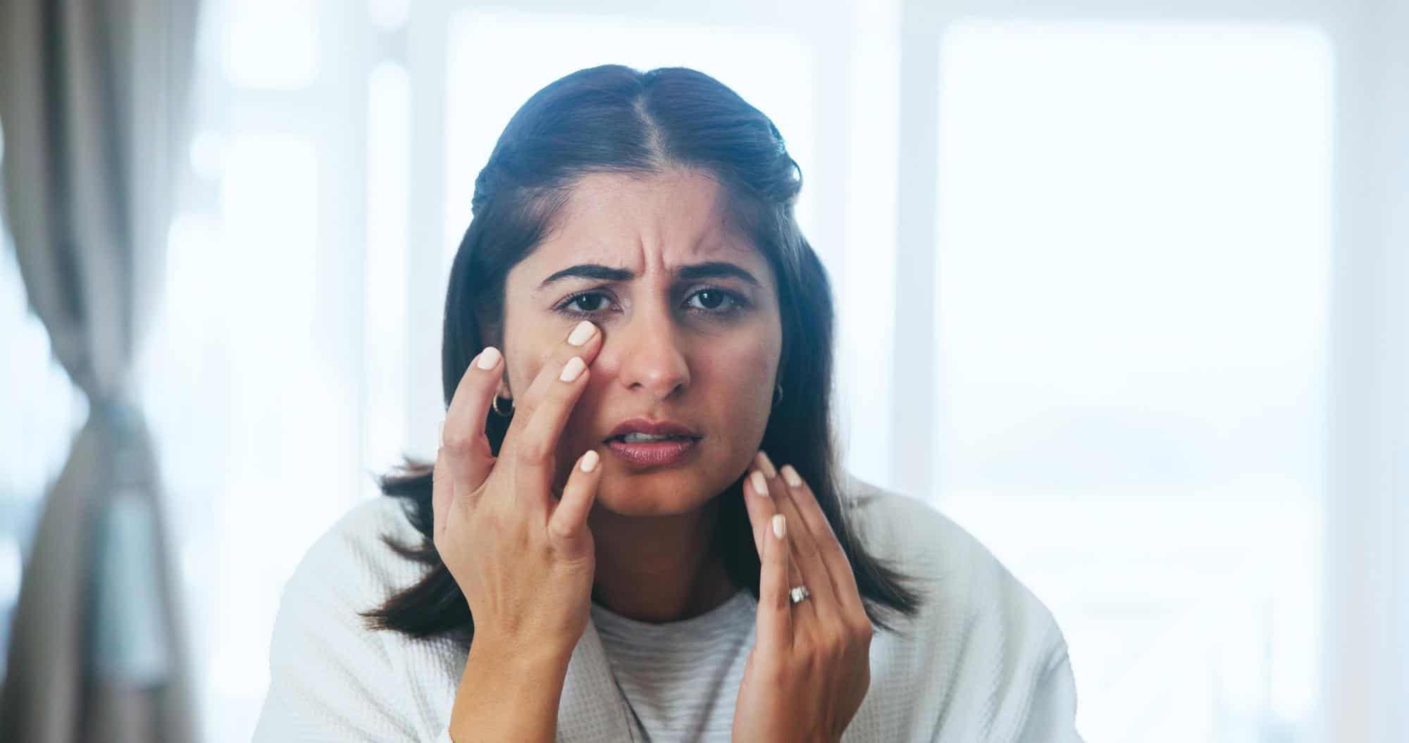 Sensitive woman experiencing facial pain or skin irritation, seeking skincare or dermatology treatment at VJ Clinics.